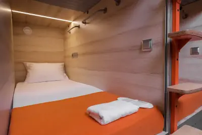 Интерьер нижней одиночной капсулы с LED-подсветкой и деревянными стенами в GettSleep Аэроэкспресс