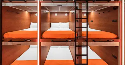 Крупный план интерьера верхней двойной капсулы GettSleep: кровать и LED-светильник для чтения